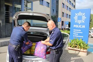 Staszowscy policjanci ładują zebrane nakrętki do radiowozu