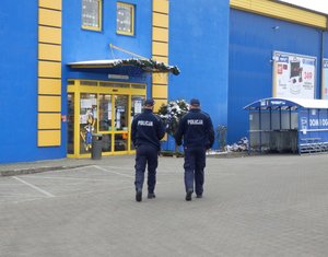 Policjanci podczas sprawdzania przestrzegania obostrzeń sanitarnych w placówkach handlowych