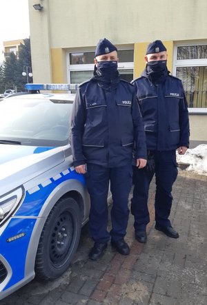 policjanci przez radiowozem