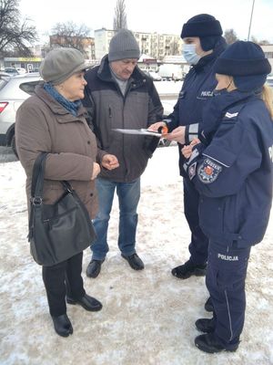 policjanci rozdający ulotki seniorom