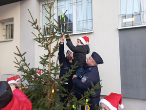 dzieci obierają choinkę z policjantami