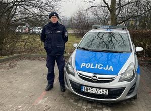 policjant stojący przy radiowozie