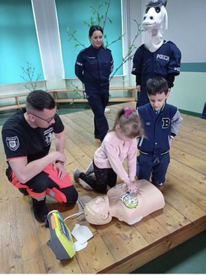 policjanci i dzieci podczas nauki pierwszej pomocy