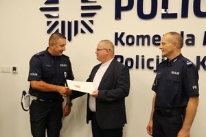 policjant otrzymuje list gratulacyjny