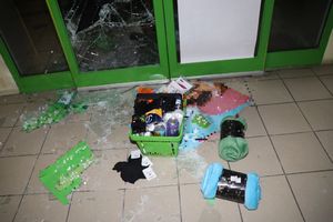 rozbita szyba w drzwiach marketu i skradzione artykuły