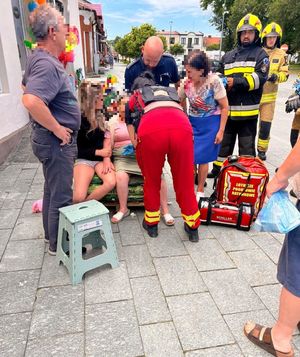 pomagający seniorce policjant i służby