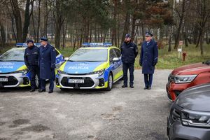 uczestnicy uroczystości oraz nowe radiowozy