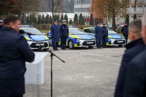 uczestnicy uroczystości oraz nowe radiowozy