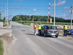 pojazd i funkcjonariusze na przejeździe kolejowym