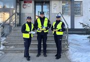 policjanci roznoszący odblaski i broszury