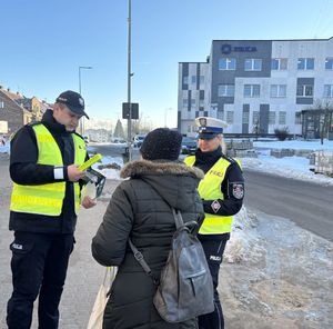 policjanci roznoszący odblaski i broszury