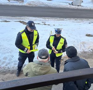 policjanci roznoszący odblaski i broszury