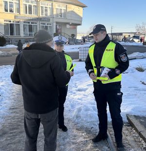policjanci roznoszący odblaski i broszury